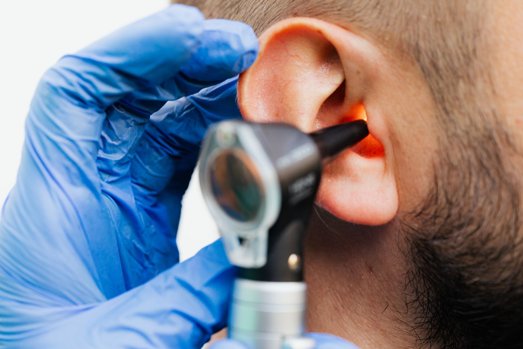 Doctor performing an ear examination with an otoscope
